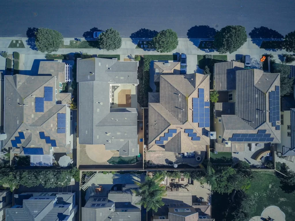 Aerial view of 4 houses on a street where 3 are powered by solar microgrids.